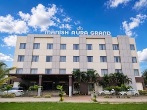 Ein Hotelgebäude mit einem Schild, auf dem 'MANISH AURA GRAND' steht.