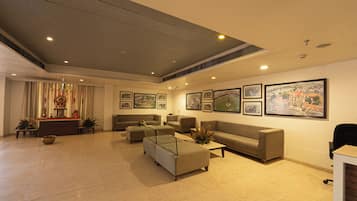 A spacious lobby with a high ceiling, multiple seating areas, and a reception desk.