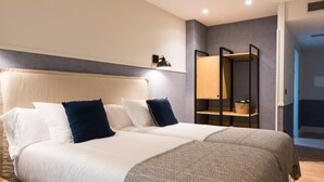 A modern bedroom with a large bed, a wardrobe, and a bedside table. - Hotel Restaurante Rias Altas (Barreiros)