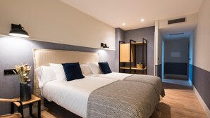 A modern bedroom with a large bed, bedside lamps, a nightstand, a mirror, and a wardrobe. - Hotel Restaurante Rias Altas (Barreiros)
