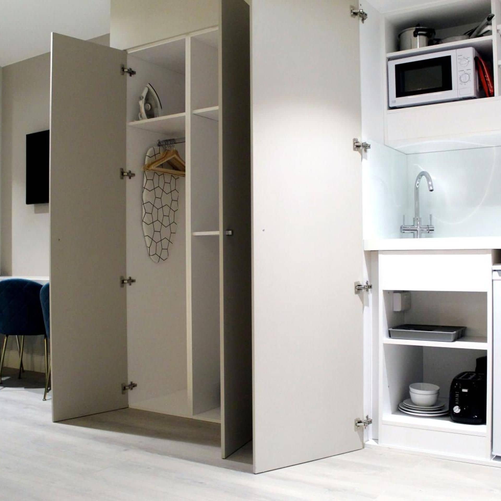 A modern kitchen with a microwave, sink, and storage cabinets.