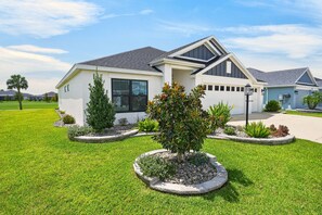 Ein modernes, zweistöckiges Haus mit gepflegtem Rasen und angelegten Blumenbeeten.