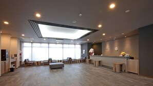 A spacious lobby with a reception desk, seating area, and large windows allowing natural light. - Hotel Route-inn Yamagata South - in Front of University Hospital (Yamagata)