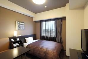 A hotel room with a bed, a desk, a chair, a TV, and a window with curtains. - Hotel Route-inn Yamagata South - in Front of University Hospital (Yamagata)