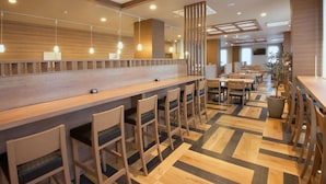 A modern interior with a long counter, bar stools, and a patterned floor. - Hotel Route-inn Yamagata South - in Front of University Hospital (Yamagata)