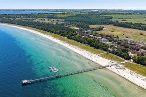 A coastal area with a beach, a pier, and a residential area with houses. - White Villas Penthouse 11 (Ostseebad Boltenhagen)