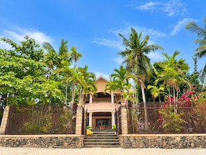 A two-story building with a stone facade, a covered entrance, and a staircase leading to the entrance.