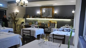Ein Restaurant mit gedeckten Tischen, einer Bar und einem Spiegel an der Wand.