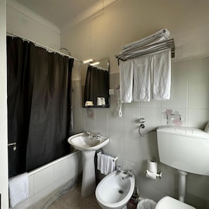 Ein Badezimmer mit einer Badewanne, zwei Waschbecken, einem Bidet und einer Toilette.