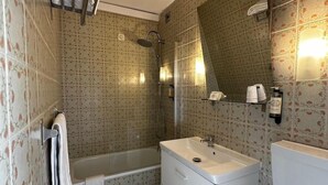 Ein Badezimmer mit Badewanne, Waschbecken, Toilette und Duschbereich.