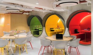 A modern office space with round tables, white chairs, and colorful walls. - lyf Cebu City (Cebu City)