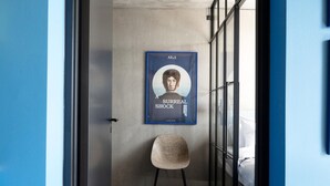 A room with a poster on the wall, a chair, and a bed. - Aarhus Stay with Free Parking (Aarhus)
