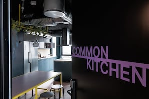 Eine moderne Küche mit schwarzer Wand und einem Schild mit der Aufschrift 'COMMON KITCHEN'.
