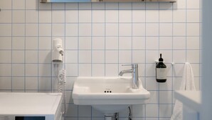 Ein Badezimmer mit einem weißen Waschbecken, einem Handtuchhalter und einer Handseifenflasche.