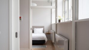 Ein modernes Schlafzimmer mit Bett, Nachttisch und Heizkörper.