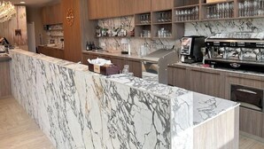 Una cocina moderna con encimeras de mármol, armarios de madera y una cafetera.