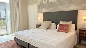 Una camera da letto con un letto grande, due comodini, una testiera e vista sull'esterno.