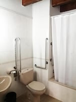 Un baño con inodoro, lavamanos y zona de ducha.