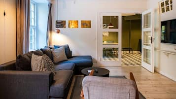 Ett modernt vardagsrum med en soffa, ett soffbord och en tv.