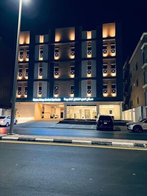 A multi-story hotel with illuminated windows and a sign indicating it is a medical facility. - Maskan Alolya (Al Khobar)