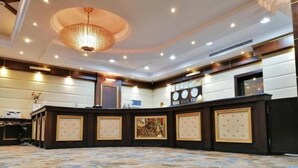 A hotel lobby with a round table, a chandelier, and a patterned carpet. - Carawan Al Khaleej Hotel Olaya (Riyadh)