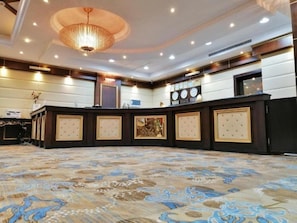 A hotel lobby with a round table, a chandelier, and a patterned carpet. - Carawan Al Khaleej Hotel Olaya (Riyadh)