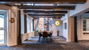 Ein modernes Interieur mit Essbereich, Treppe und großem Fenster.