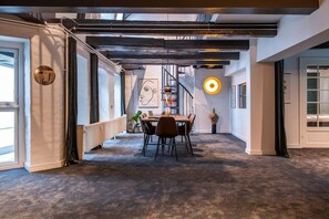 A modern interior with a dining area, a staircase, and a large window. - Residence Near Amalienborg Palace (København)