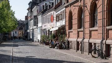 Een straat met keien omzoomd door historische gebouwen, waarvan sommigen bewegwijzerd zijn.
