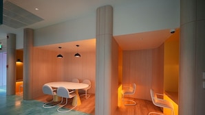 A modern interior with a round table and chairs, wooden flooring, and a ceiling with recessed lighting. - Go Hotel Ban Chang (Ban Chang)
