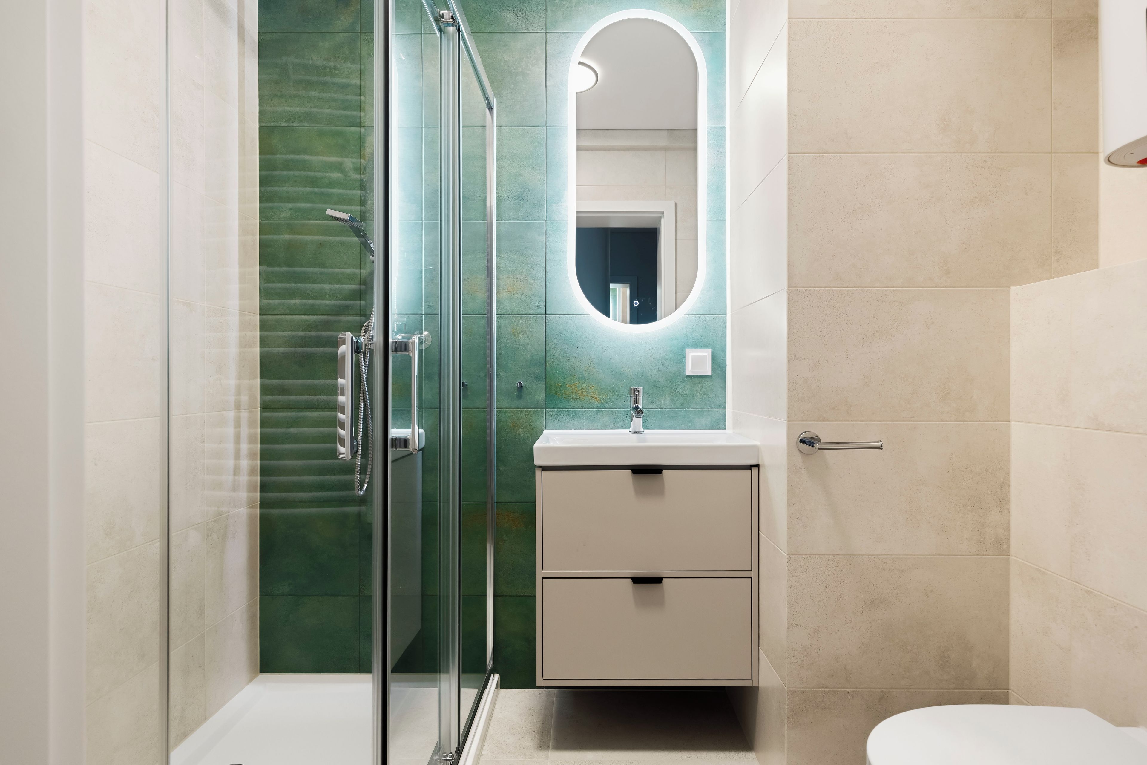 A modern bathroom with a glass shower enclosure, a vanity with a mirror, and a toilet.