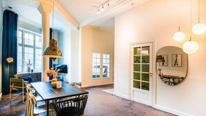 Un espace repas comprenant une table, des chaises et un luminaire suspendu.