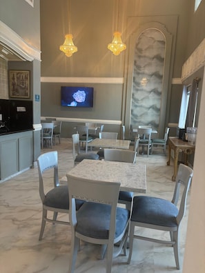 A restaurant with marble flooring, modern chairs, and pendant lighting. - La Quinta Inn Brownsville (Los Fresnos)