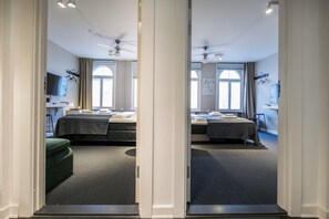 A mirrored view of a hotel room with two beds, a desk, and a chair. - Historic Center Copenhagen Home (København)