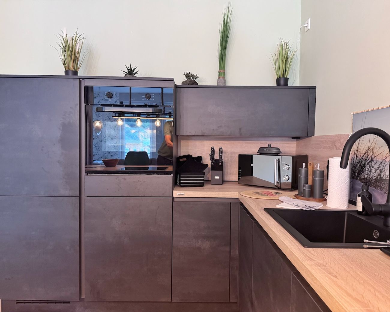 Eine moderne Küche mit Backofen, Mikrowelle und Spüle.