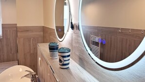 A bathroom with a mirror, a sink, and two decorative containers on the counter. - Kogge 6 Apartment - Sassnitz (Sassnitz)
