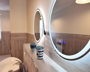 A bathroom with a mirror, a sink, and two decorative containers on the counter. - Kogge 6 Apartment - Sassnitz (Sassnitz)