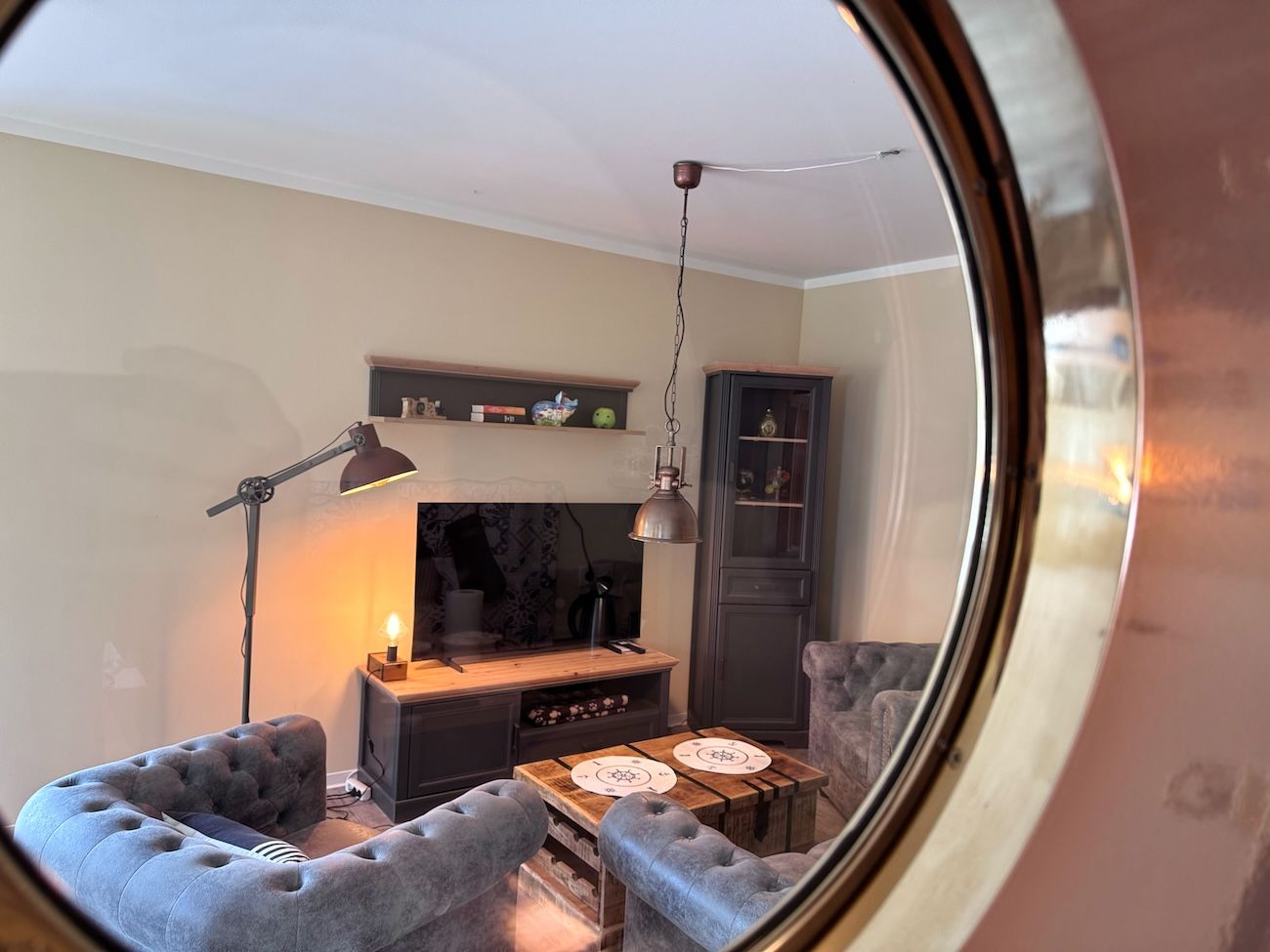 A living room with a sofa, a coffee table, a TV, and a cabinet.