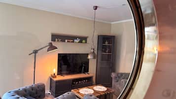 A living room with a sofa, a coffee table, a TV, and a cabinet.