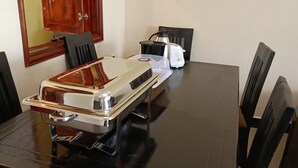 Een eettafel met een broodrooster, waterkoker en een dienblad.