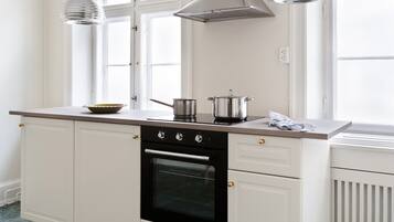 A kitchen with a stove, oven, and a window with a view.