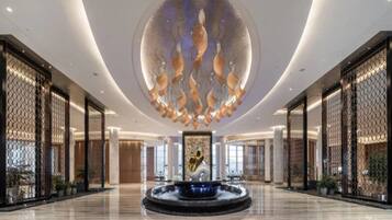 A spacious lobby with a central fountain, high ceilings, and modern decor.