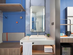 A modern bathroom with a large mirror, sink, and shower. There is a towel rack, a small plant, and a coffee maker on the counter. - Holiday Inn Express Changzhou Henglin (Changzhou)