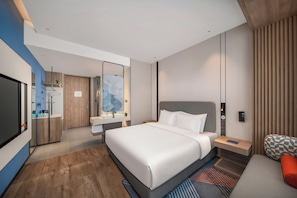 A modern hotel room with a large bed, a TV, a desk, and a seating area. - Holiday Inn Express Changzhou Henglin (Changzhou)