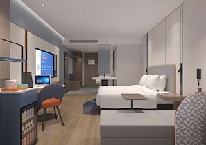 Una habitación de hotel moderna con cama, escritorio, silla y una mesita.