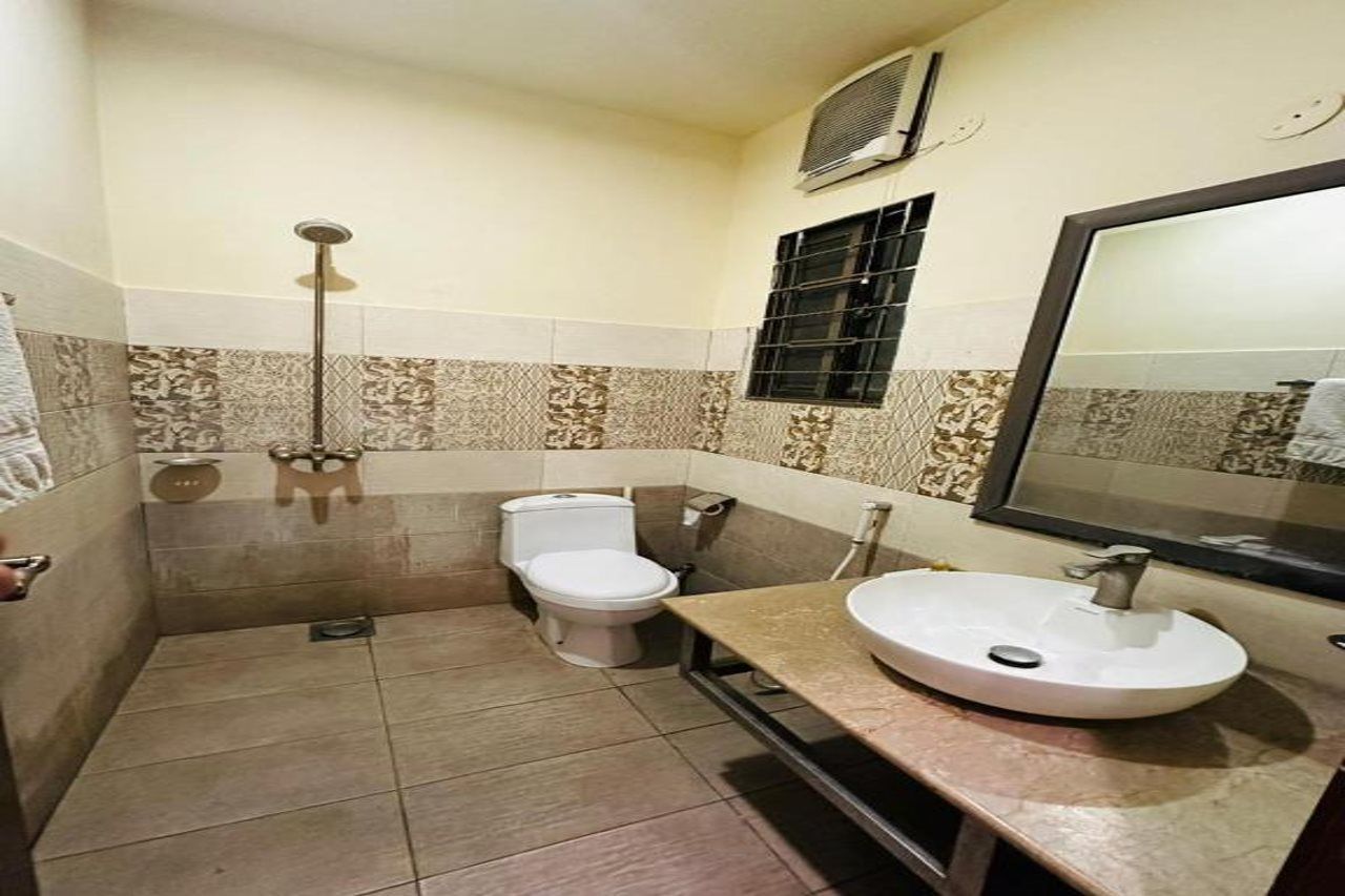 A bathroom with a toilet, sink, and shower.