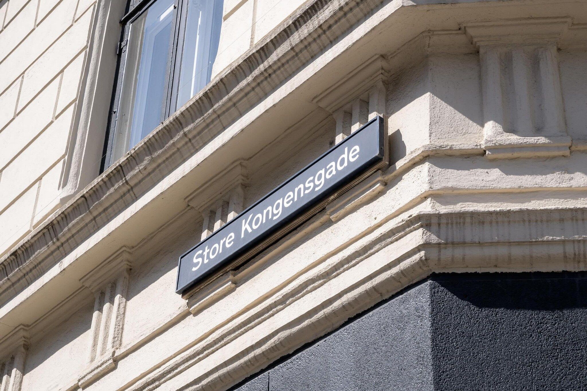 A building corner with a sign reading 'Store Kongensgade' and classical architectural details.