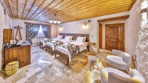 Ein Schlafzimmer mit zwei Betten, Holzboden, Steinböden und einer rustikalen Tür.