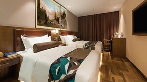 A hotel room with two beds, a large painting, a television, and a wooden floor. - James Joyce Coffetel (Beijing)