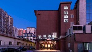 A hotel with a prominent entrance and signage in a foreign language. - James Joyce Coffetel (Beijing)